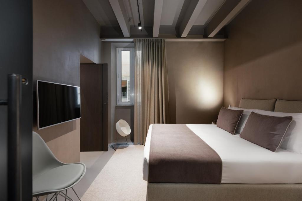 ein Schlafzimmer mit einem großen Bett und einem TV in der Unterkunft Elysium Suites collection in Rom