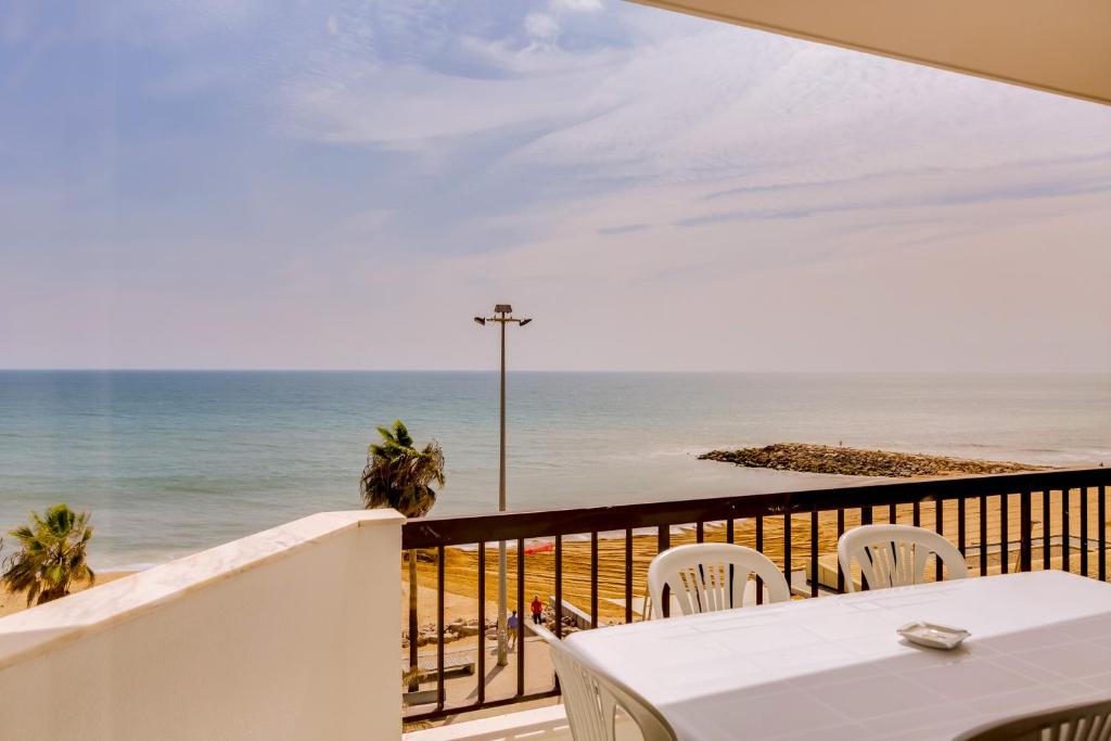 クアルテイラにあるAtlântico View - Beach front - Quarteiraの海を望むバルコニー(テーブル、椅子付)