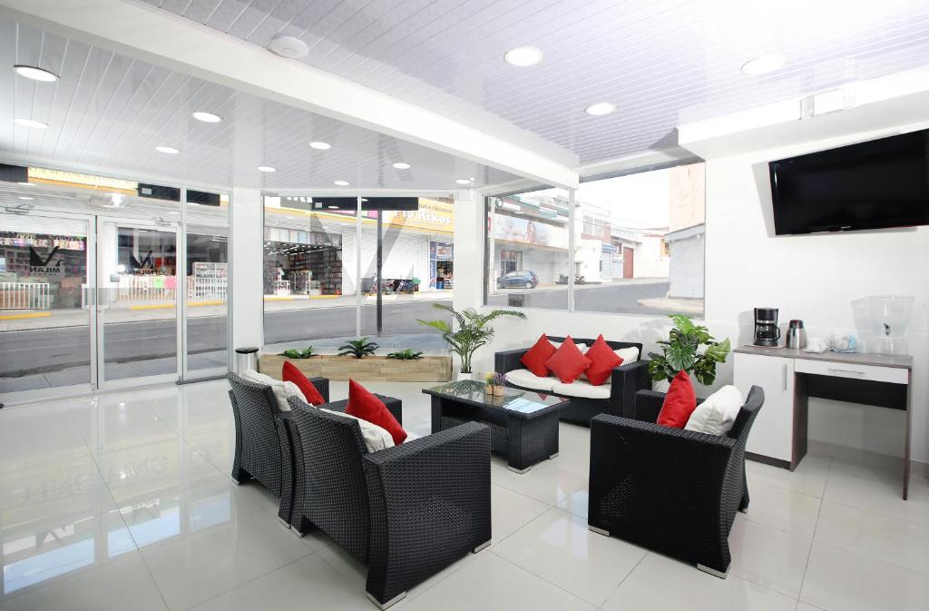 - un hall avec des chaises, une table et une télévision dans l'établissement Hotel Milan Costa Rica, à San José