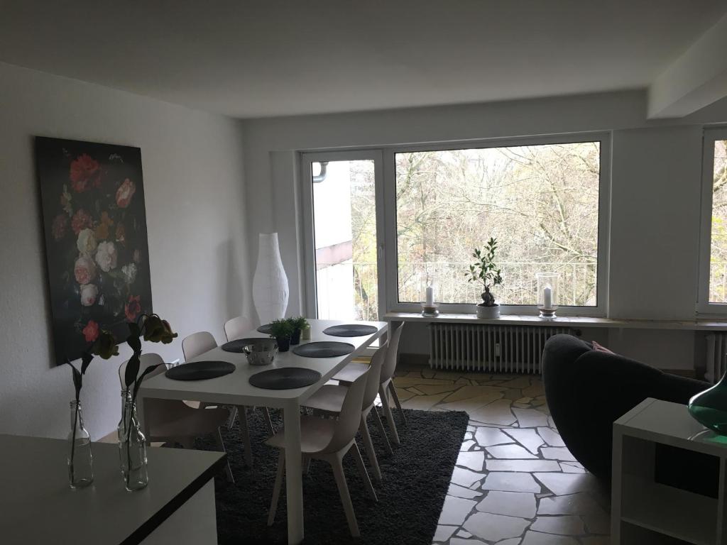 una sala da pranzo con tavolo, sedie e finestra di Ferienwohnung Parkblick a Brema