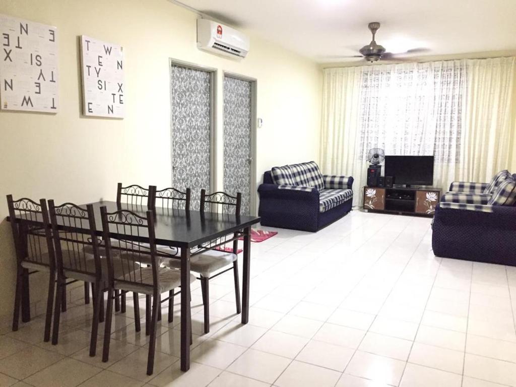 ein Wohnzimmer mit einem Esstisch und Stühlen in der Unterkunft Sri Nabalu Apartment Platinum Putatan in Kota Kinabalu