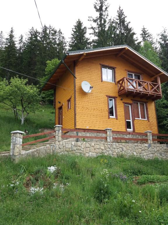 a large wooden house with a stone wall at Смериковий in Yaremche