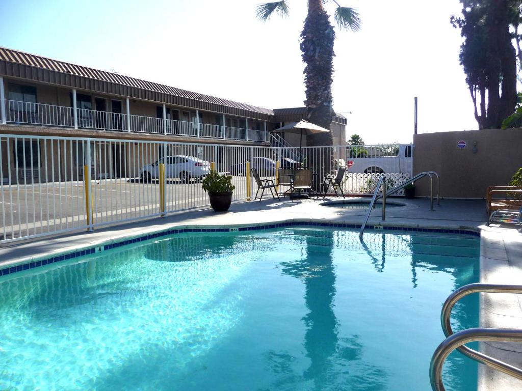 a swimming pool with blue water in front of a building at Rainbow Inn in Anaheim