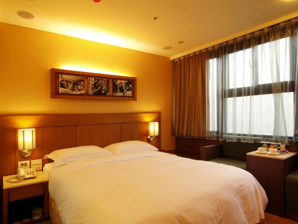 東鑫商務旅館Eastern Star Hotel في تايبيه: غرفة فندقية بسرير كبير ونافذة