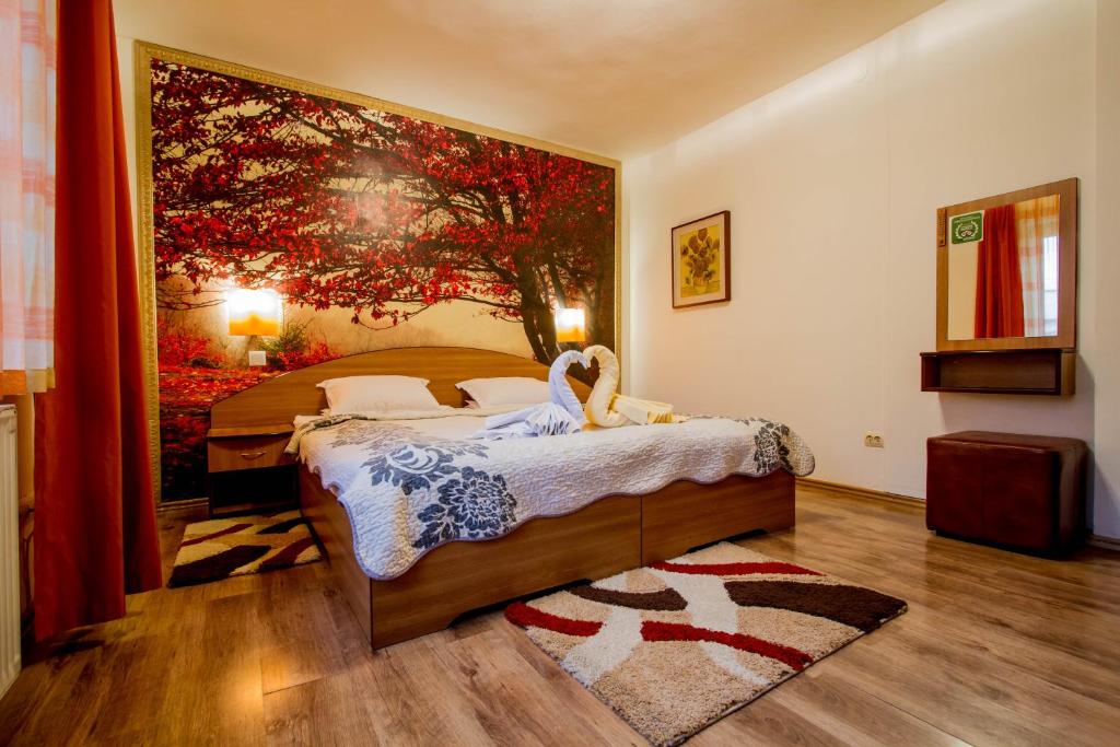 um quarto com uma cama com um quadro na parede em Pension Casa Timar em Brasov