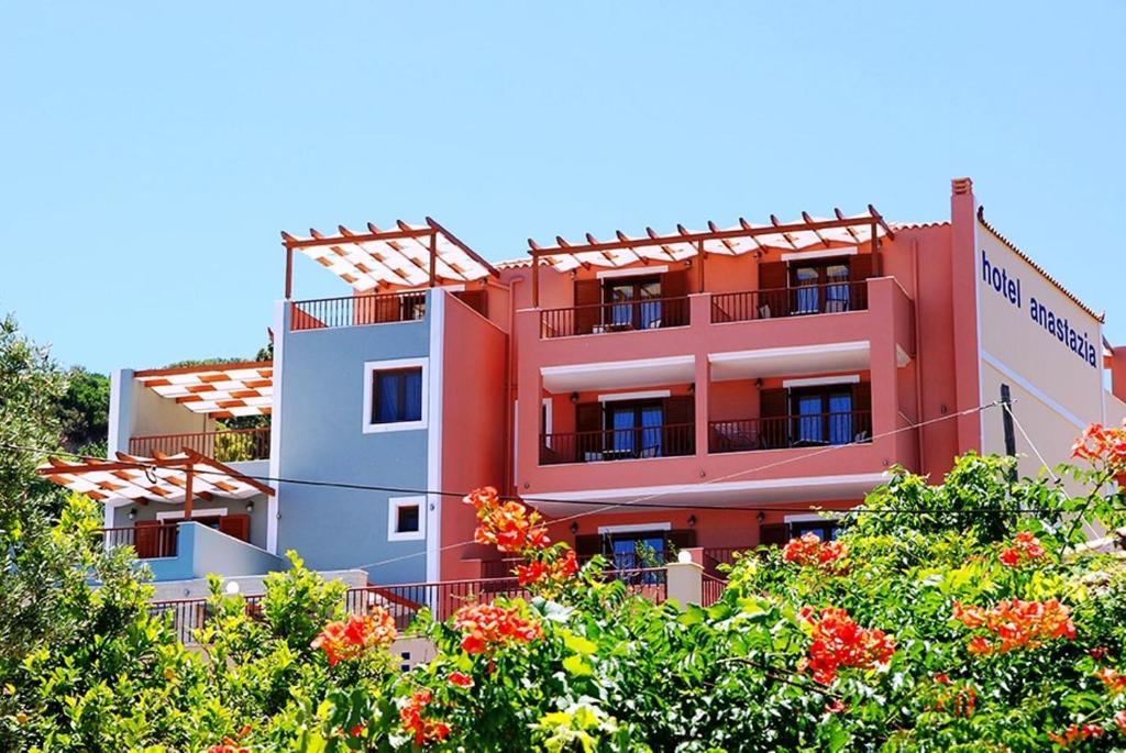 a red building with trees in front of it at Hotel Anastazia in Poros