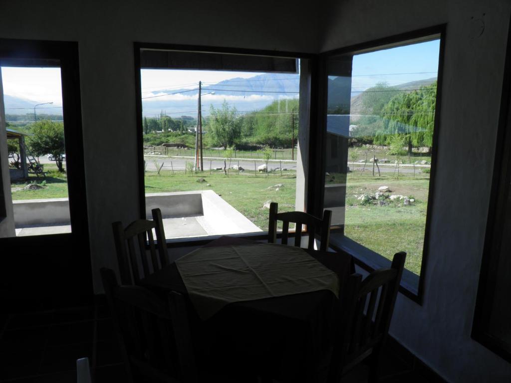 mesa y sillas en una habitación con ventana en LOS MENIRES II en Tafí del Valle