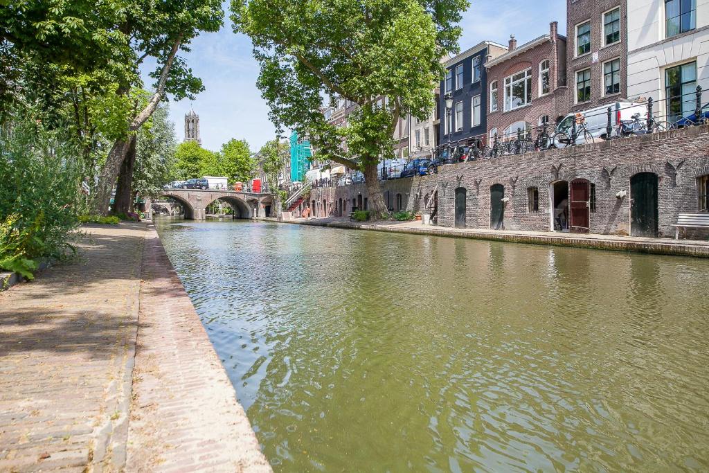 a river in a city with buildings and a bridge at De Verrassing aan de Werf in Utrecht
