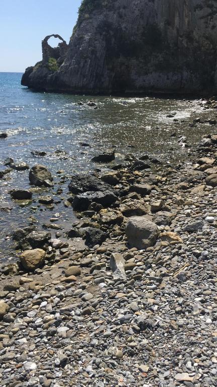 a rocky beach with rocks and the water at La Casa di Lulu' in Palinuro