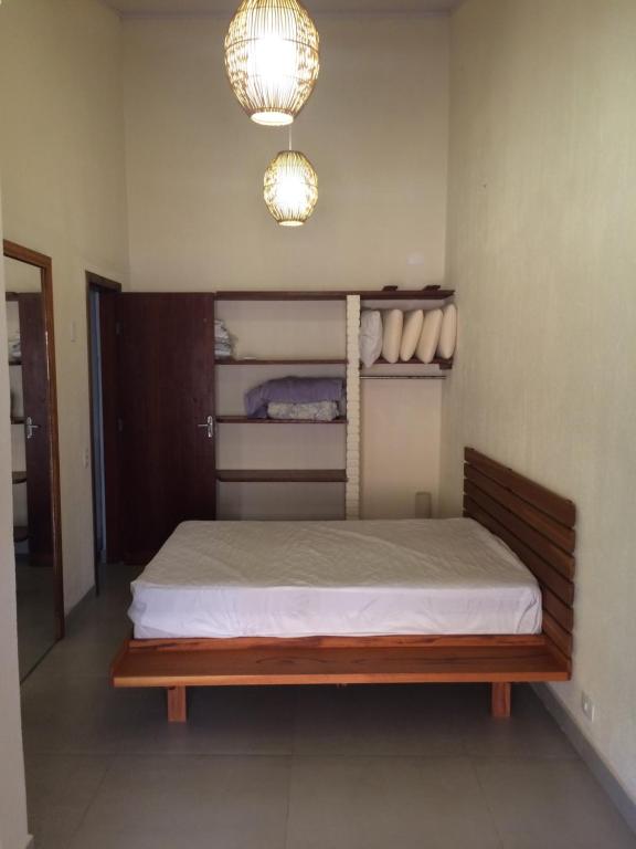 um quarto com uma cama com uma estrutura de madeira e luzes em Privacidade e Conforto no Saco da Capela em Ilhabela