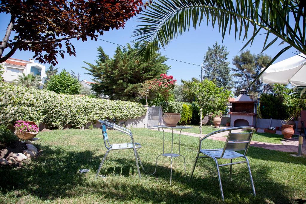 two chairs sitting in the grass in a yard at Apartments Eleni 4 Seasons in Hanioti