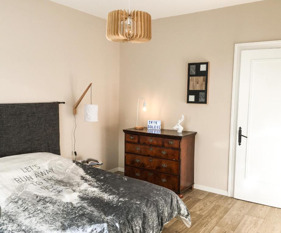 - une chambre avec un lit, une commode et une lampe dans l'établissement Beau Site, à Villard-de-Lans