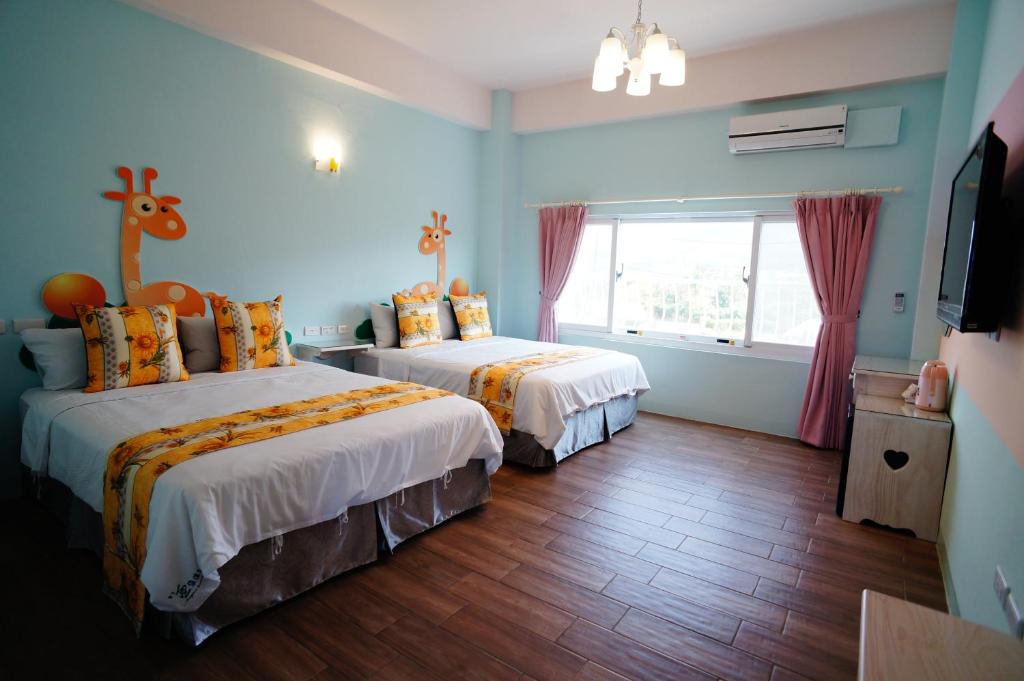 two beds in a room with blue walls at Kenting Avignon in Hengchun South Gate