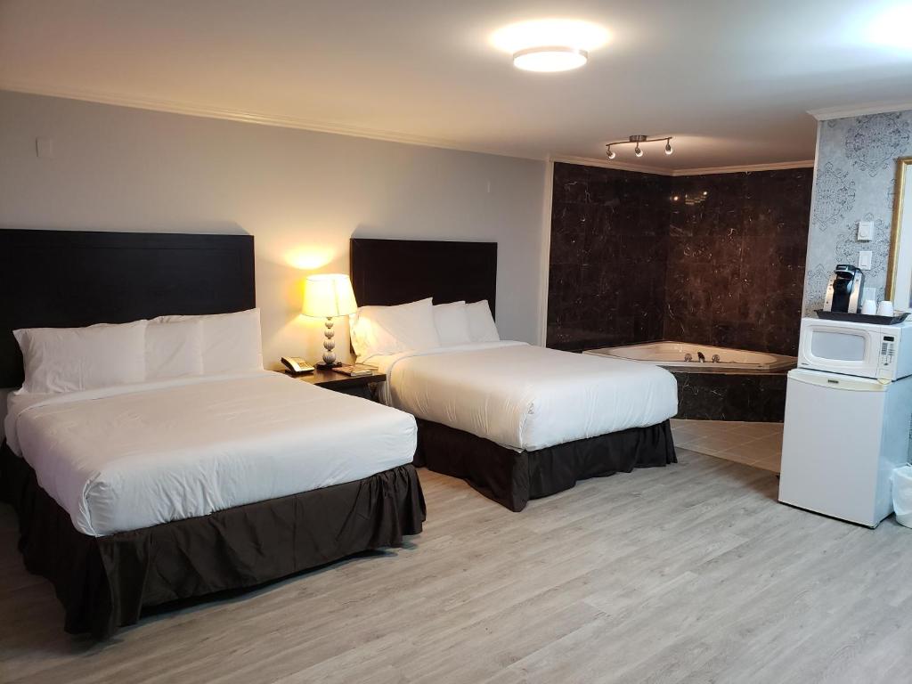 een hotelkamer met 2 bedden en een bad bij Regency Inn & Suites in Cornwall