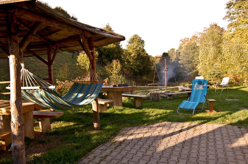 grupa stołów piknikowych i hamaków w parku w obiekcie Dom nad potokiem w mieście Krzyżanów