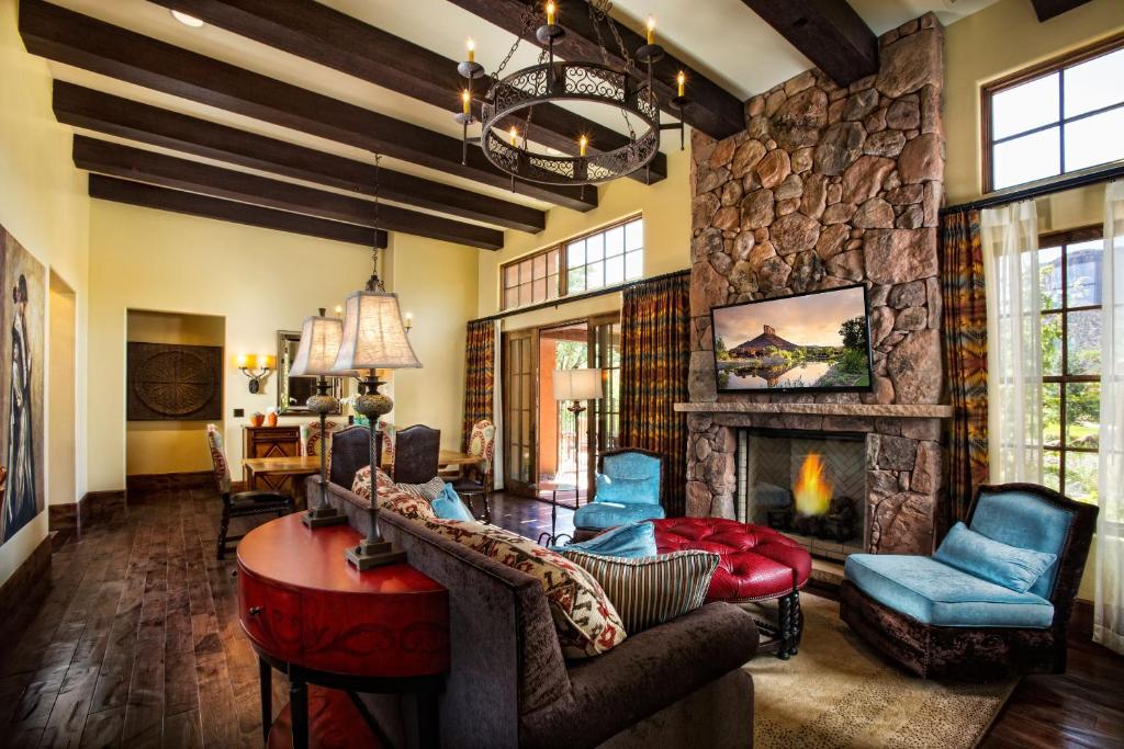 a living room with a stone fireplace and blue chairs at Gateway Canyons Resort, a Noble House Resort in Gateway