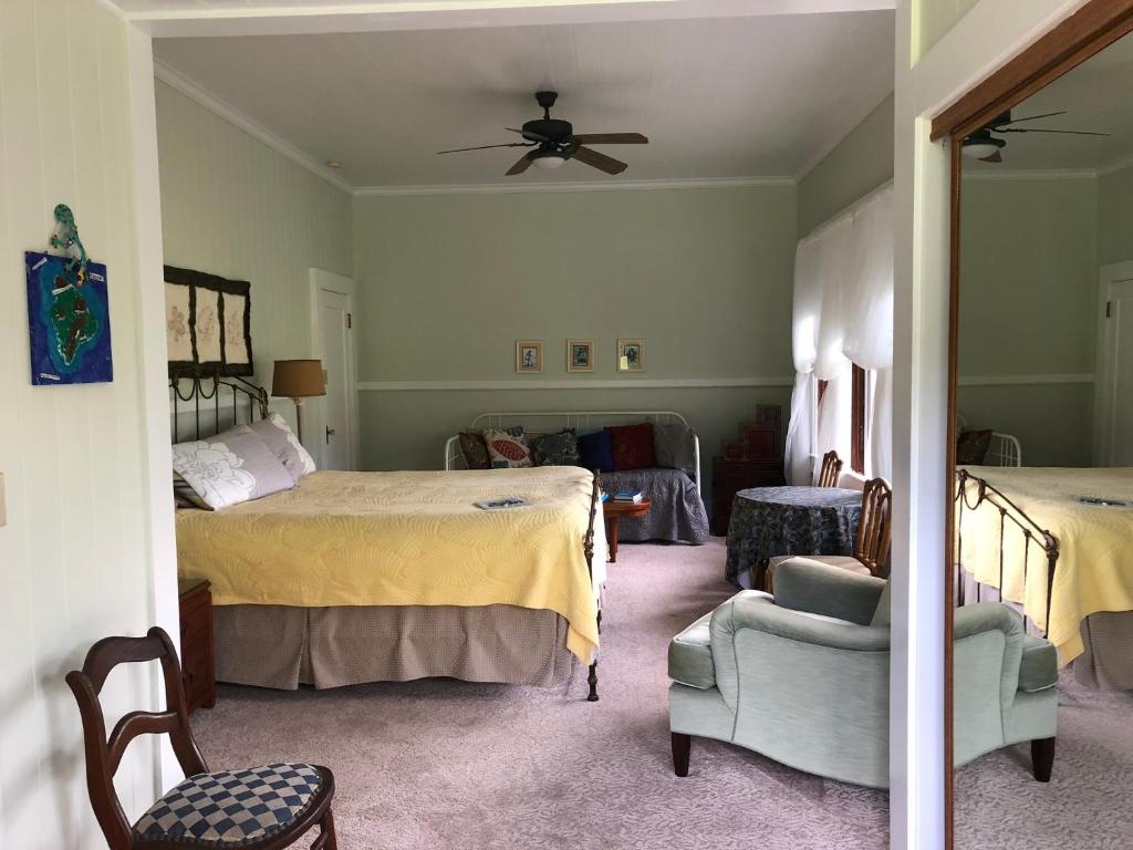 a bedroom with two beds and a ceiling fan at Old Hawaiian Bed and Breakfast in Hilo