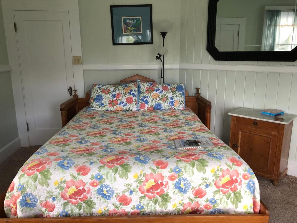 a bed with a floral comforter in a bedroom at Old Hawaiian Bed and Breakfast in Hilo