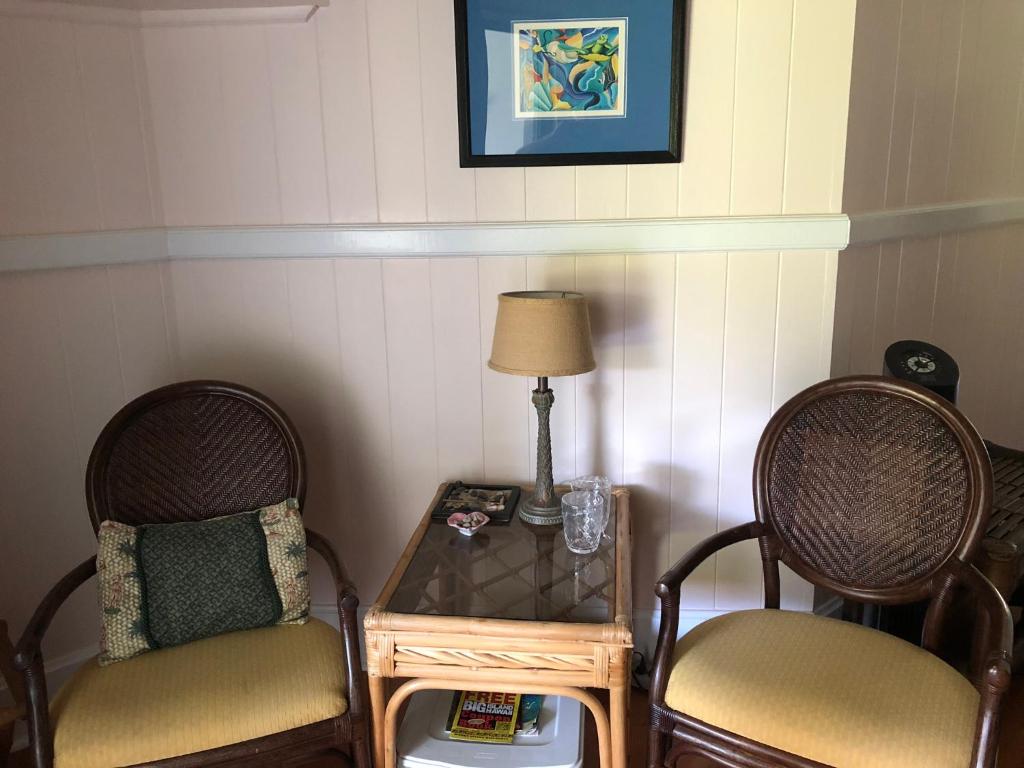 a room with two chairs and a table with a lamp at Old Hawaiian Bed and Breakfast in Hilo