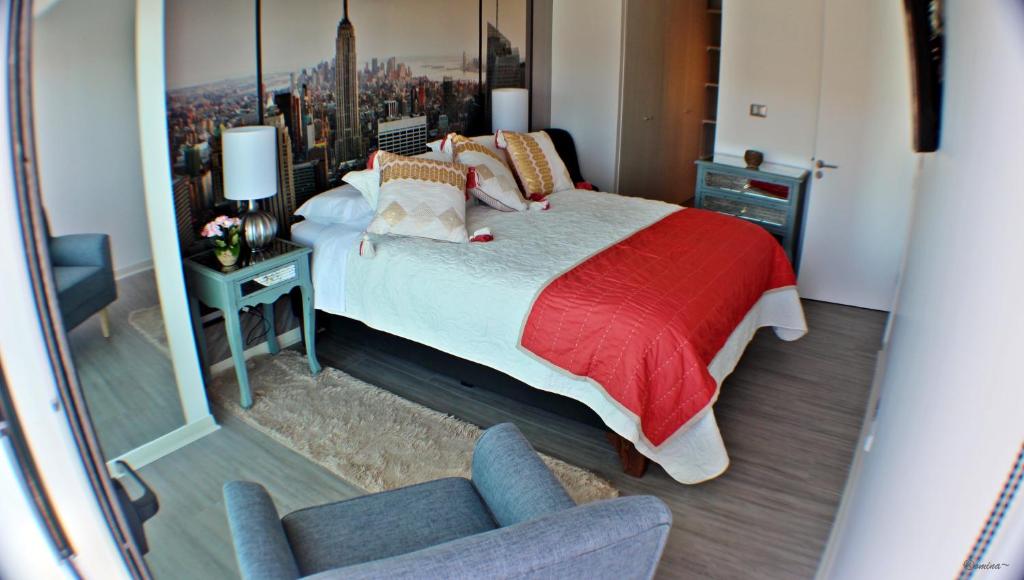 安托法加斯塔的住宿－Departamento de lujo Antofagasta，一间卧室配有一张床、一把椅子和镜子