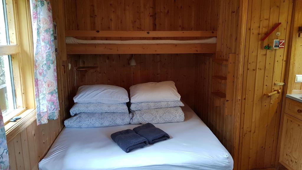 a bed in a wooden room with two pillows at Cozy Cabin in the Woods in Selfoss