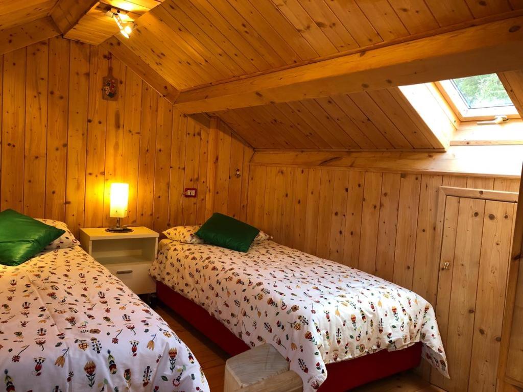 sypialnia z 2 łóżkami w drewnianym domku w obiekcie Casa Margherita w mieście Tarvisio