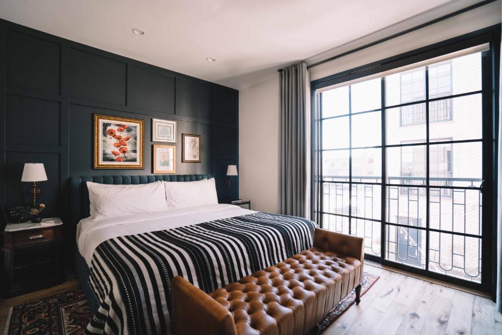 um quarto com uma cama e uma grande janela em The Ramble Hotel em Denver