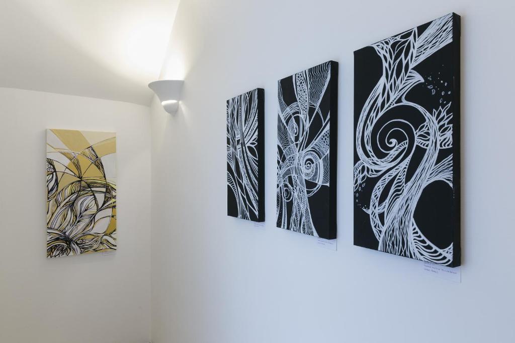 een groep van vier schilderijen aan een muur bij Art Apartment Navona Square in Rome