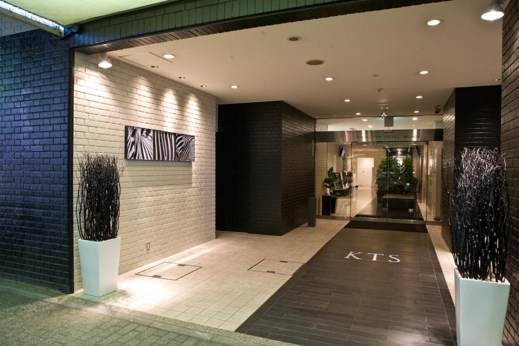 a lobby of a building with a kips sign on the wall at Hamilton Hotel Black in Nagoya