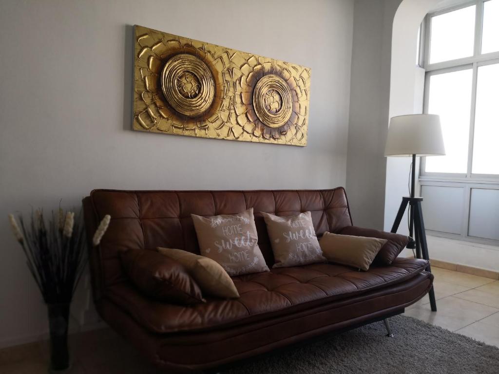 a brown leather couch with pillows in a living room at Graça Lovers 2 in Lisbon
