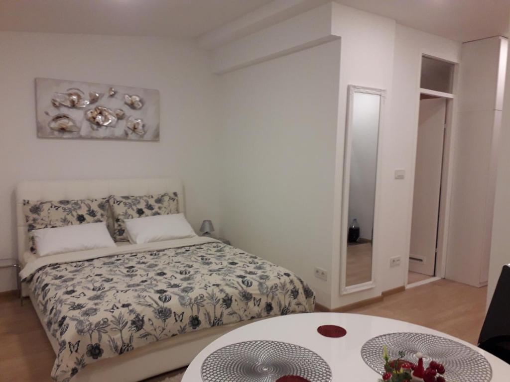a bedroom with a bed and a table and a mirror at APARTMAN MMVG STUDIO Zagreb Airport in Velika Gorica
