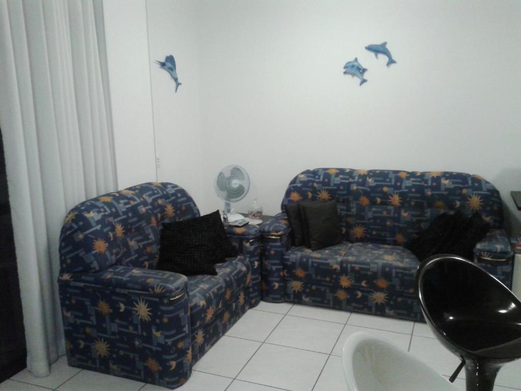 Sala de estar con 2 sillas y pájaros en la pared en Apartamento em Meia Praia, Itapema, SC., en Itapema