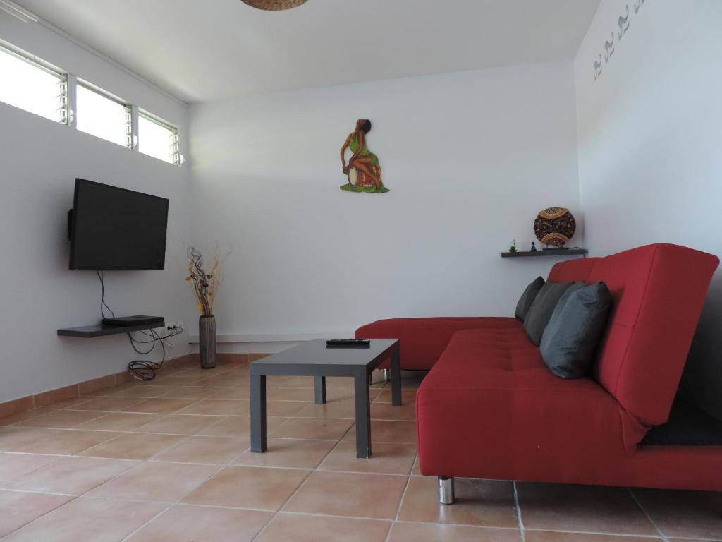 sala de estar con sofá rojo y mesa en Any's Appart, en Fort-de-France