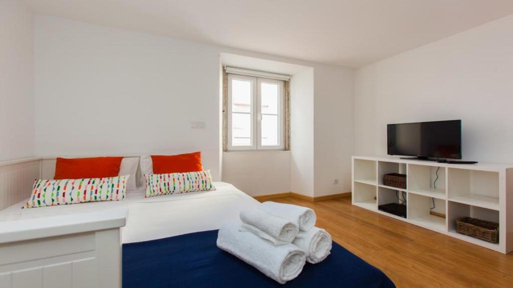 a white bedroom with a bed with towels on it at Lisbon City Sweet Studio in Lisbon