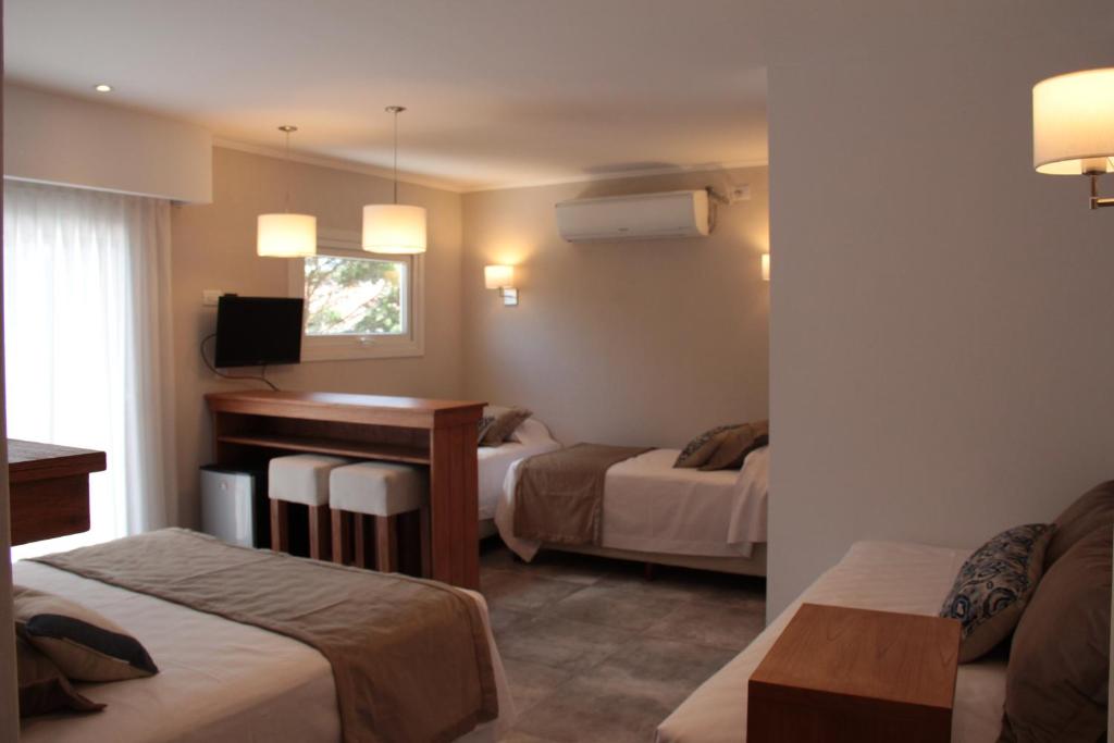 una habitación de hotel con dos camas y televisión en el Hotel Romina de Villa Gesell