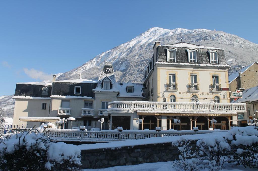a large building with a snow covered mountain in the background at Hôtel Tourmalet in Luz-Saint-Sauveur