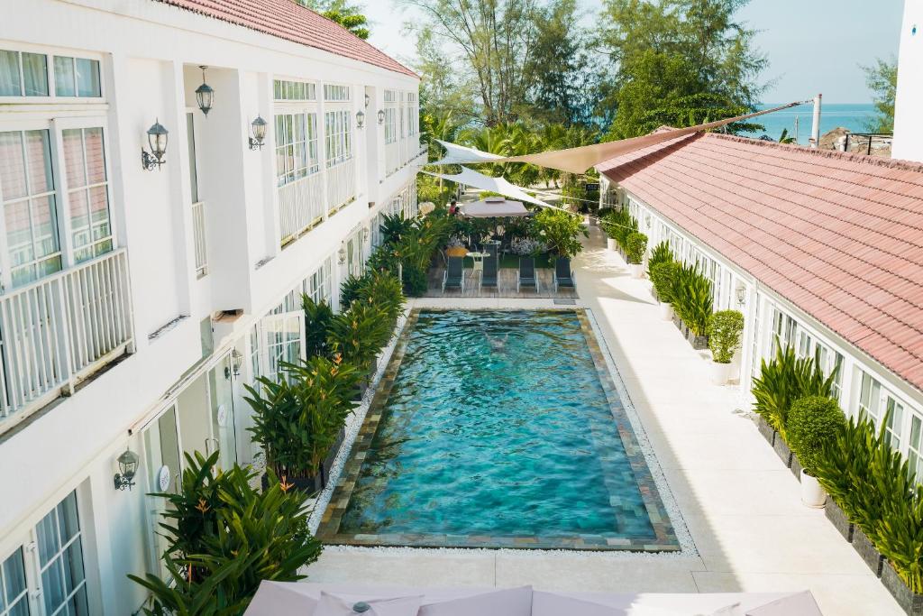 een uitzicht over een zwembad tussen twee gebouwen bij White Boutique Hotel and Residences in Sihanoukville
