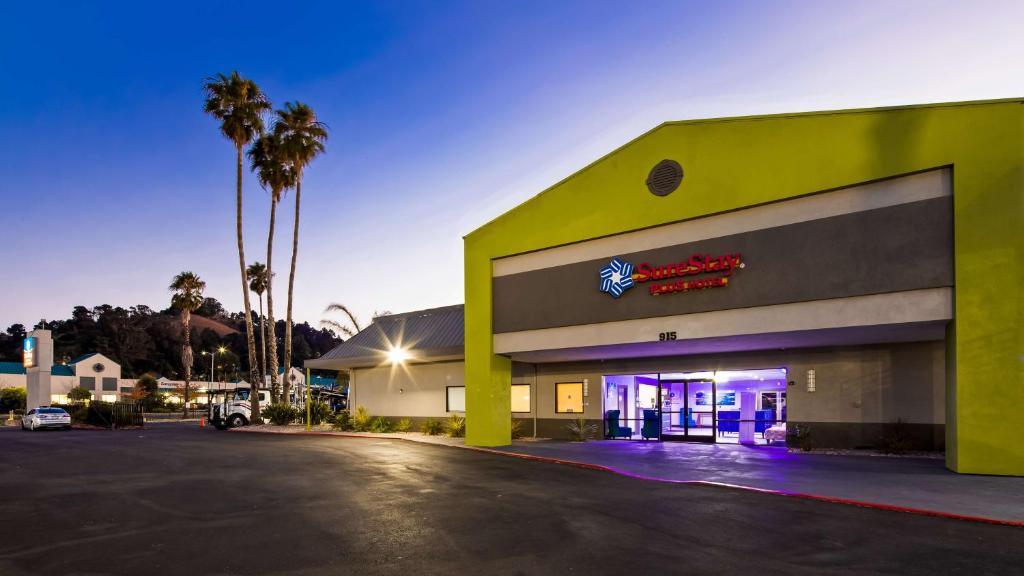 a gas station with a neon sign in a parking lot at SureStay Plus Hotel by Best Western Point Richmond in Richmond