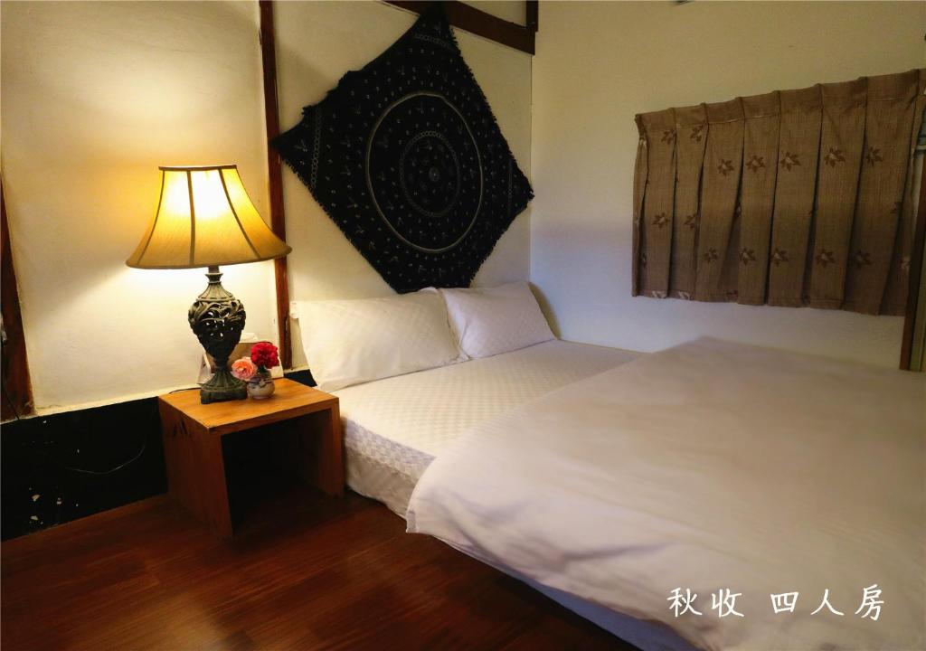 a bedroom with a bed and a lamp on a night stand at 玉蟾園民宿 寵物友善 YuChanYuan B&amp;B in Chishang