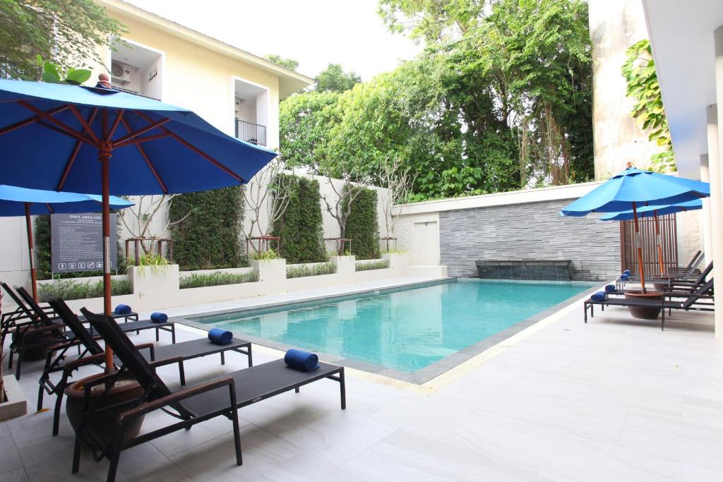 卡隆沙灘的住宿－Adema Boutique Karon，一个带椅子和遮阳伞的游泳池