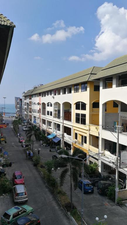 a street with buildings and cars parked in a parking lot at Abani Inn in Jomtien Beach