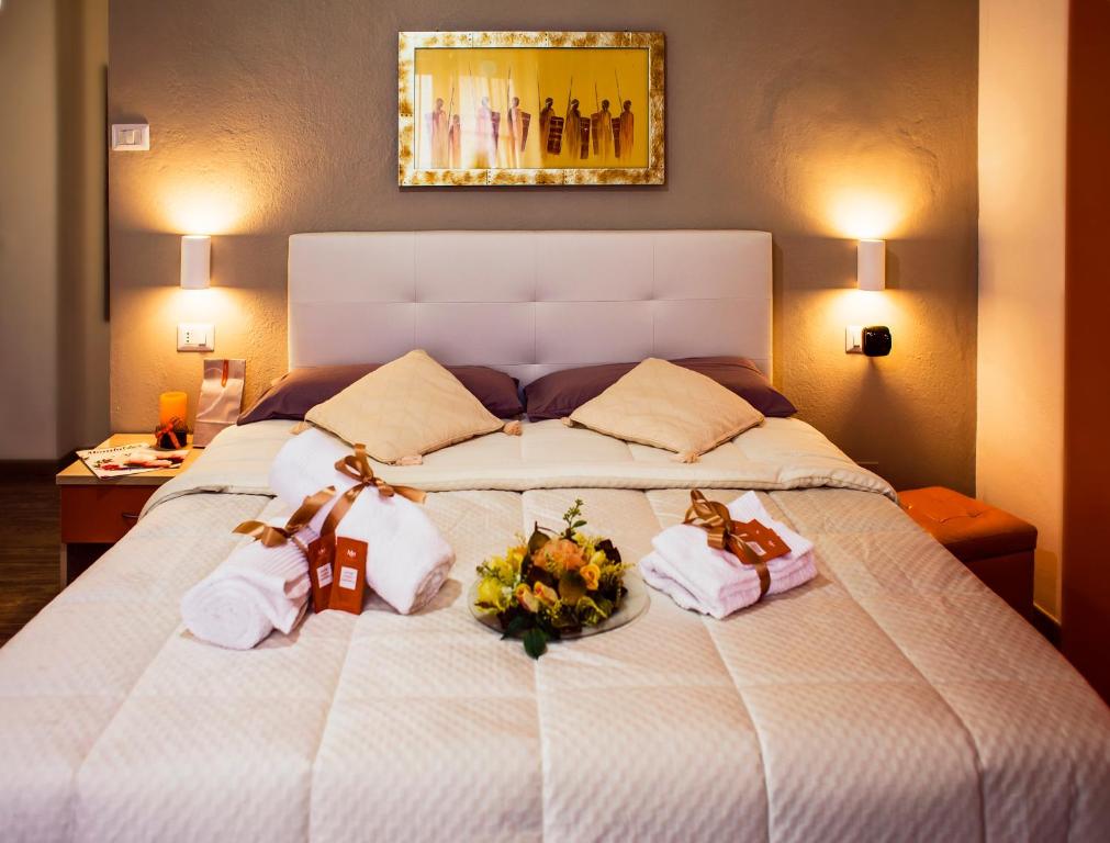 ein Bett mit zwei Handtüchern und Blumen drauf in der Unterkunft Sweet Rooms Cagliari in Cagliari