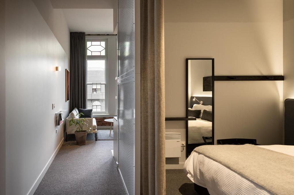 a hotel room with a bed and a mirror at The Chamberson in Dunedin