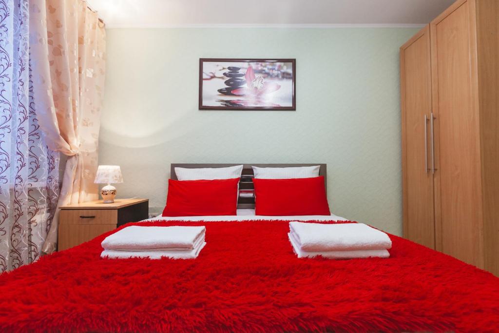 ノヴィ・ウレンゴイにあるFive Stars Skver Stroiteleyの赤いベッド1台、赤い枕2つが備わるベッドルーム1室が備わります。