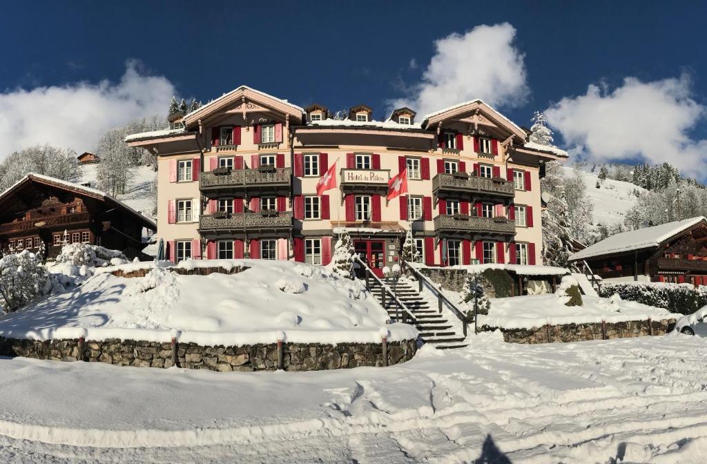 a large building with snow in front of it at Historic Hotel du Pillon in Les Diablerets