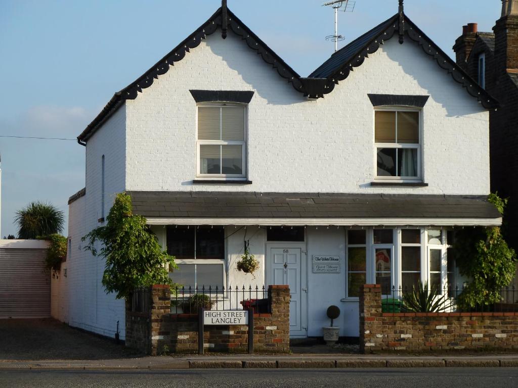 a white house with a sign in front of it at The White House Guest House in Slough