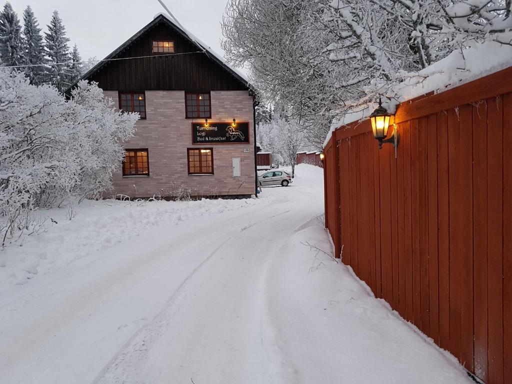 una casa coperta di neve accanto a una recinzione di Vargheden B&B och trädgård a Malung