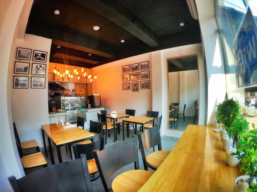 Un restaurante con mesas y sillas y una cocina. en VIA VARANASI - A Boutique Hotel at Assi Ghat, en Varanasi