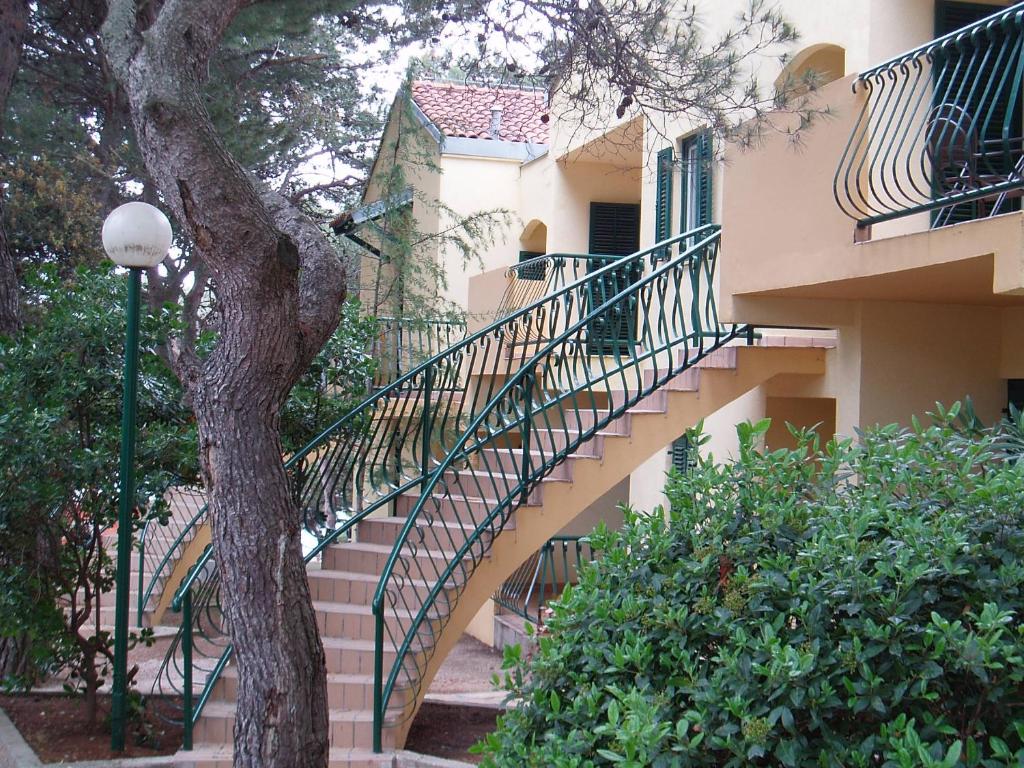 un escalier menant à un bâtiment avec un escalier dans l'établissement Kozarica Apartments, à Pakoštane