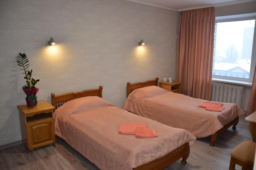 a hotel room with two beds and a window at Hotel Trias in Kyiv